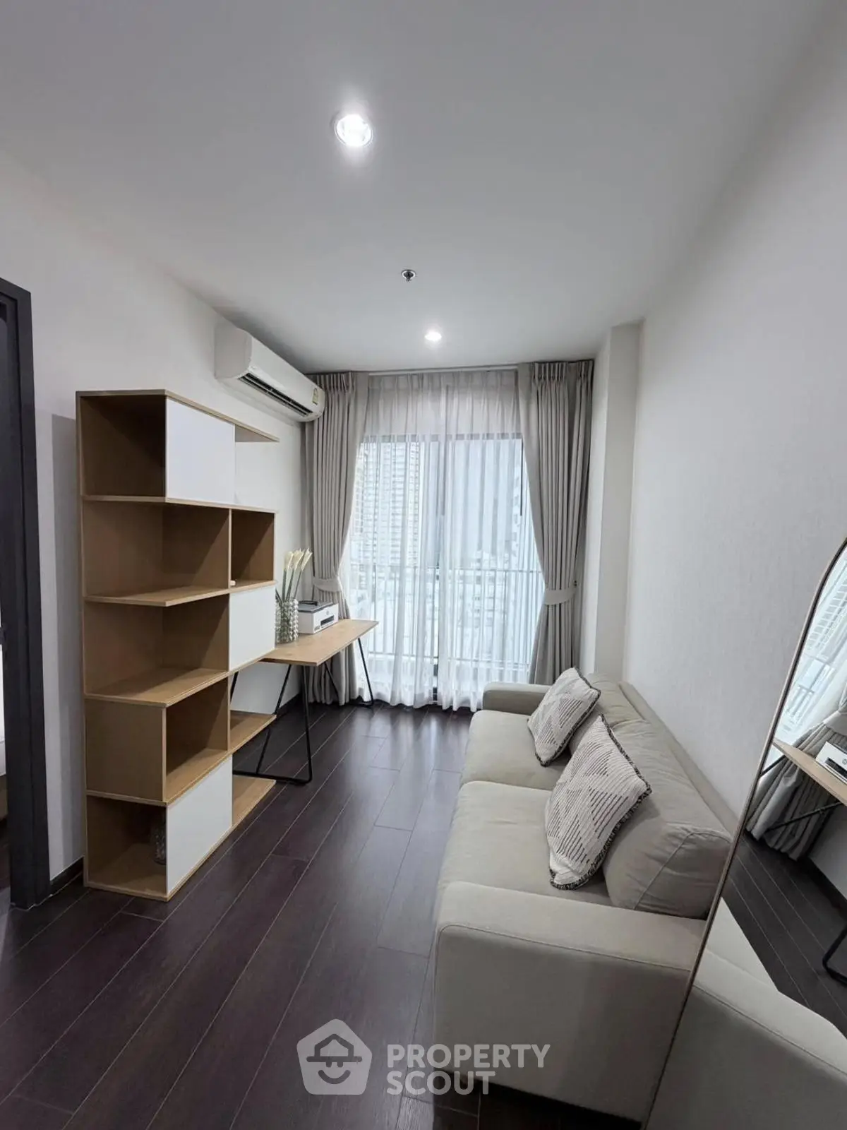 Modern living room with sleek design and city view from window.