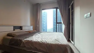 Modern bedroom with large window and city view in high-rise apartment