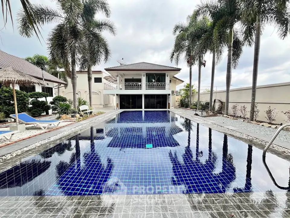 Luxurious villa with stunning pool and palm trees, perfect for tropical living.