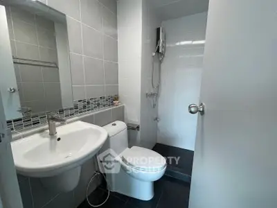 Modern bathroom with sleek fixtures and tiled walls in a contemporary apartment.