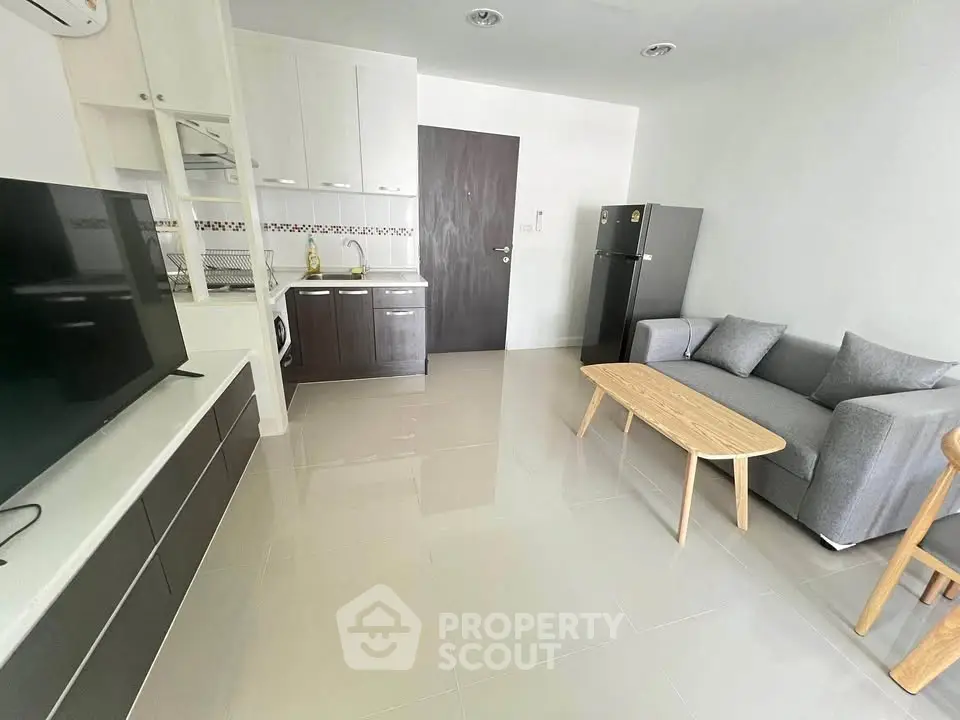 Modern living room with sleek furniture and open kitchen layout in a stylish apartment.