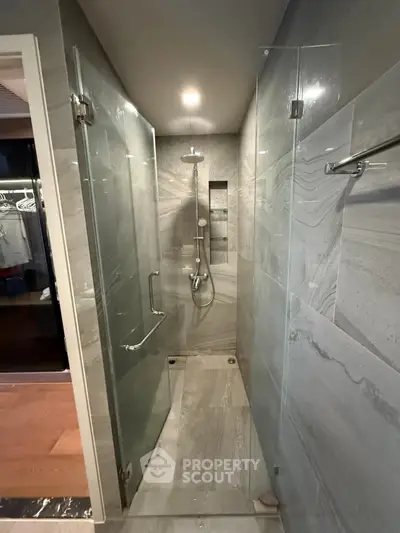 Modern bathroom with sleek glass shower and elegant gray tiles