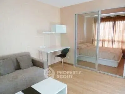 Modern studio apartment with cozy living area and bedroom separated by sliding glass doors.