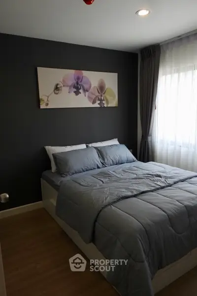 Cozy bedroom with modern decor and natural light, featuring a comfortable bed and elegant wall art.