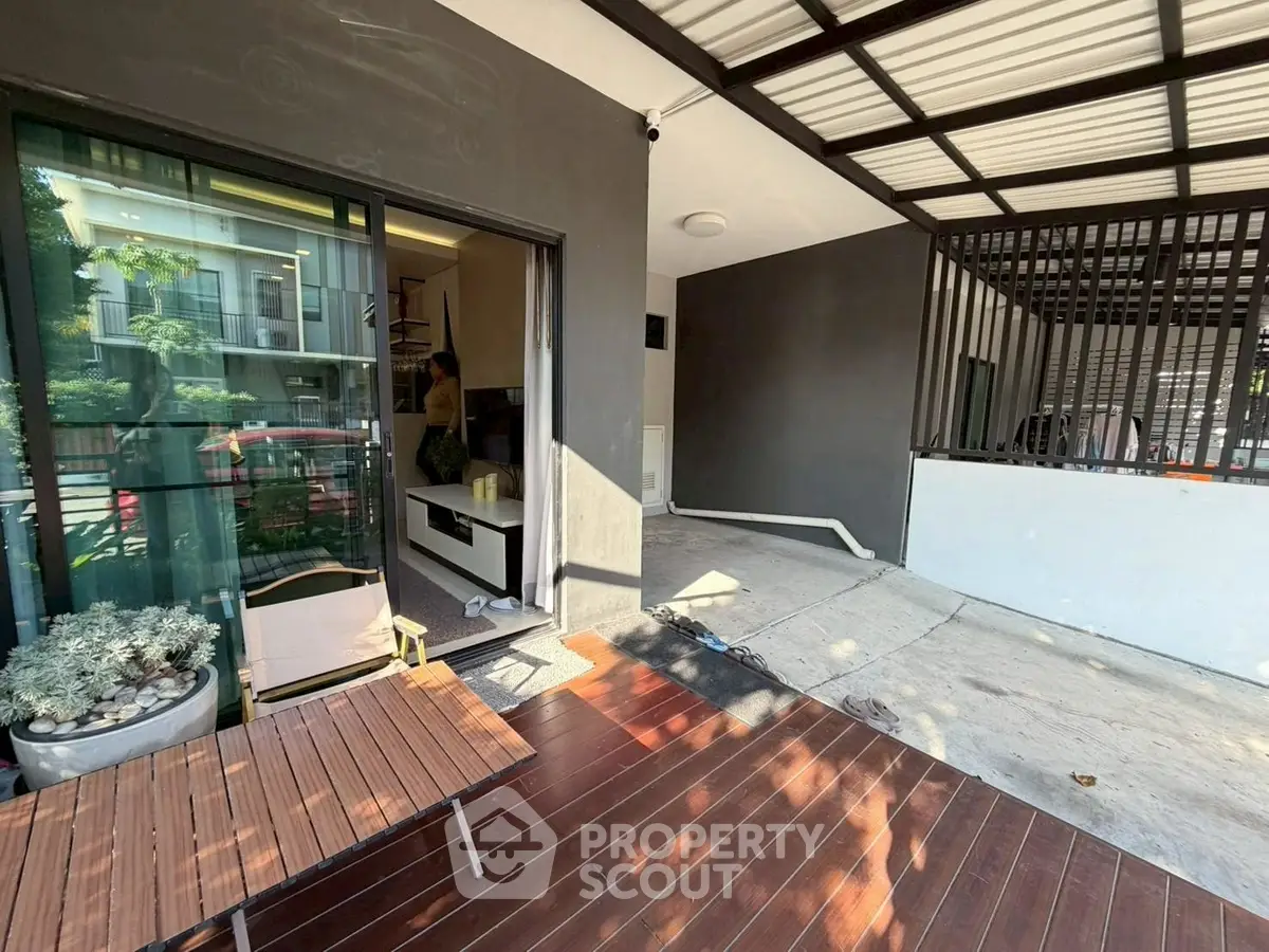 Modern home entrance with wooden deck and sliding glass doors