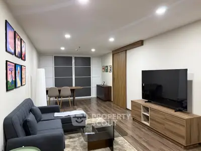 Modern living room with sleek furniture and large TV, perfect for relaxation and entertainment.