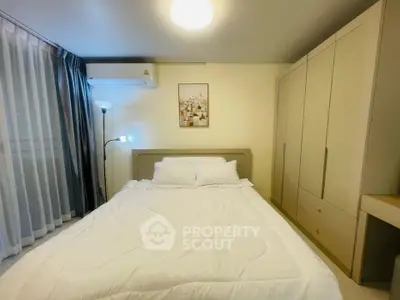Cozy bedroom with modern furnishings and ample storage space in a stylish apartment.