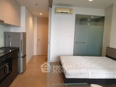Modern studio apartment with sleek kitchen and cozy sleeping area
