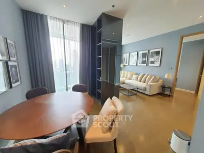 Modern living room with dining area and stylish decor in a high-rise apartment.