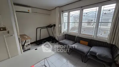 Cozy living room with treadmill and large windows for natural light
