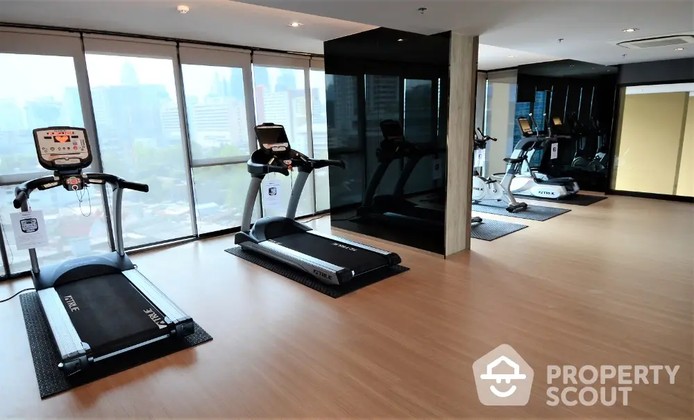 Modern gym with city view and state-of-the-art equipment in luxury apartment building