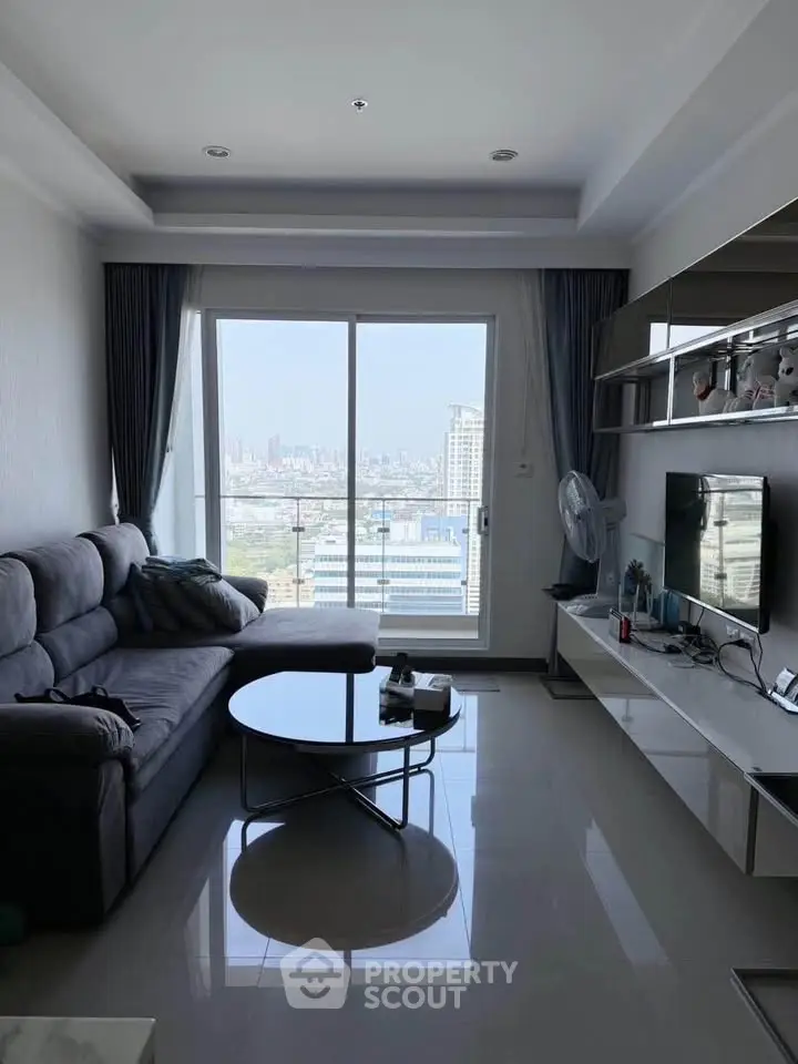 Modern living room with city view, sleek furniture, and ample natural light.