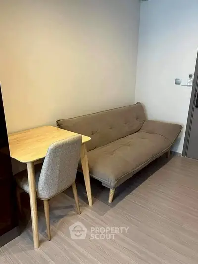 Cozy living room with modern sofa and wooden table, perfect for compact spaces.