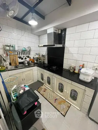 Charming kitchen with modern appliances and sleek black countertops.