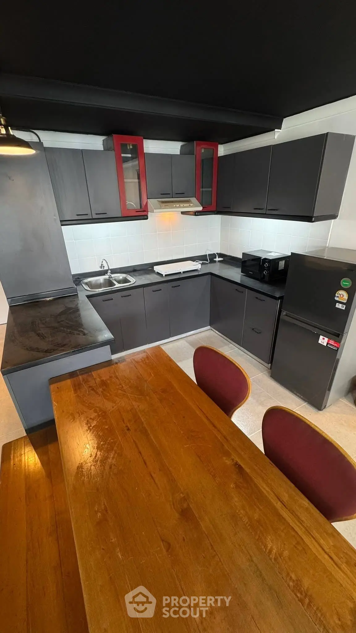 Modern kitchen with sleek black cabinets and wooden dining table