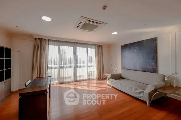Spacious living room with large windows and modern decor in a luxury apartment.
