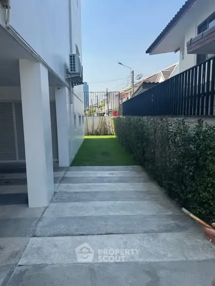 Modern building exterior with clean lines and lush greenery, perfect for urban living.