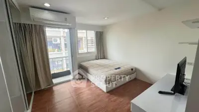 Modern bedroom with balcony access and natural light in urban apartment
