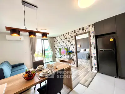 Modern open-plan living room with stylish dining area and kitchen, featuring a cozy bedroom view.