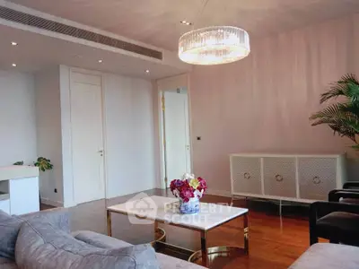 Elegant living room with modern chandelier and stylish furniture, perfect for luxury living.