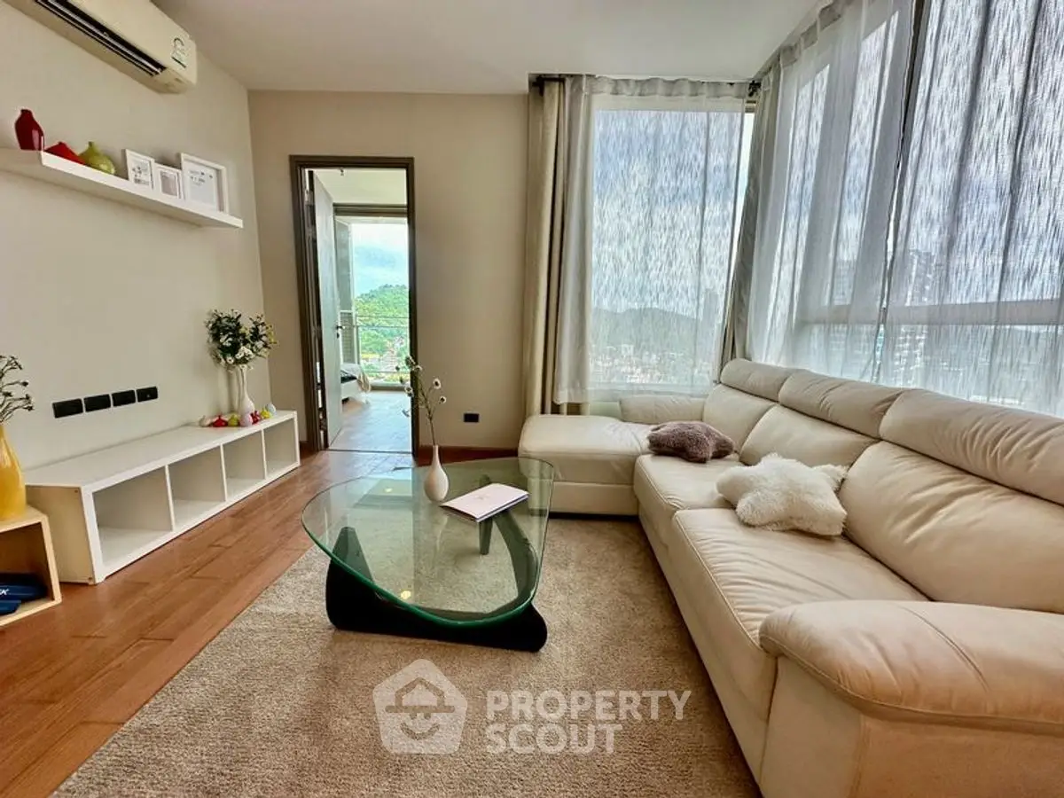 Spacious living room with modern decor and large windows offering scenic views.