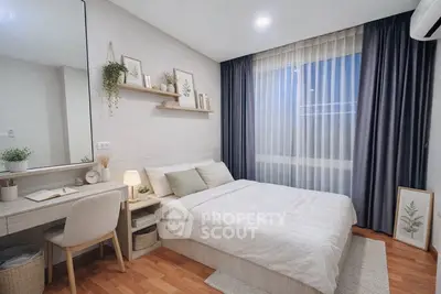 Cozy bedroom with modern decor and natural light, featuring a stylish desk and elegant curtains.