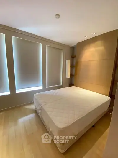 Spacious bedroom with large windows and modern design, perfect for comfort and relaxation.