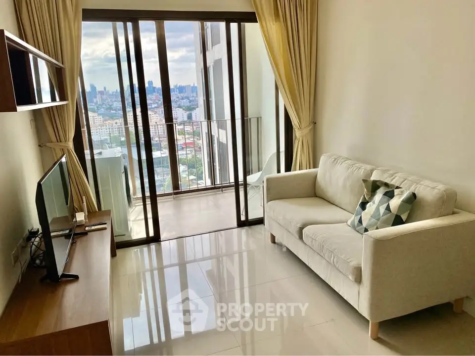 Modern living room with city view and balcony access, featuring cozy sofa and sleek TV setup.