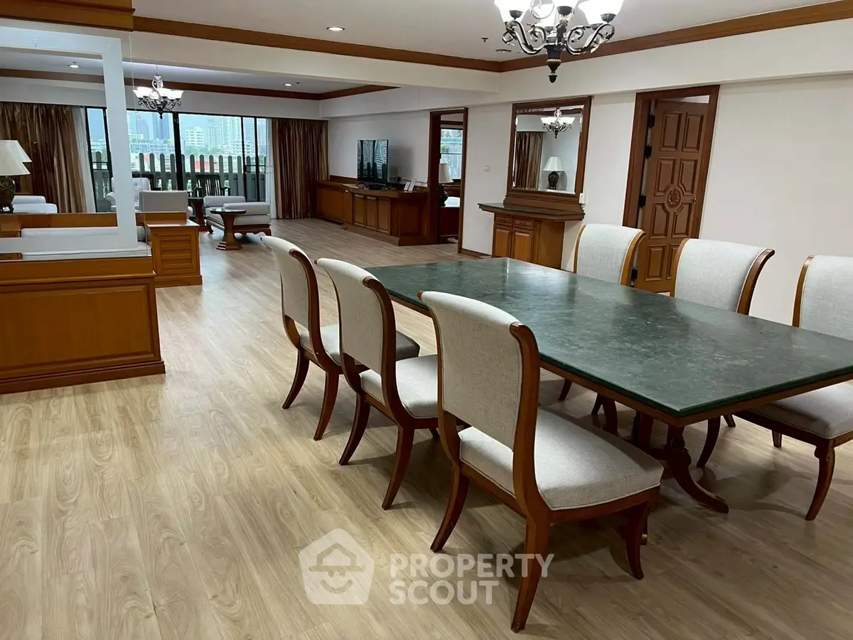 Spacious dining area with elegant wooden furniture and large windows offering city views.