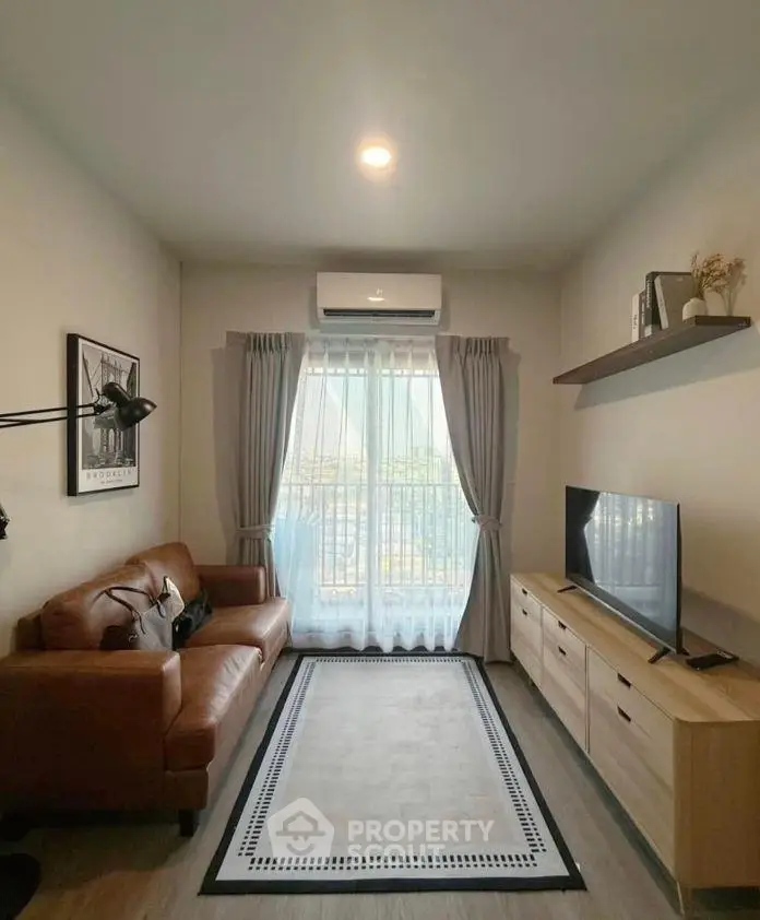 Cozy living room with leather sofa, TV, and natural light from large window.