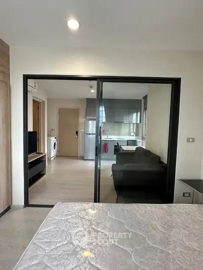 Modern apartment interior with open layout, featuring a cozy living area and sleek kitchen.