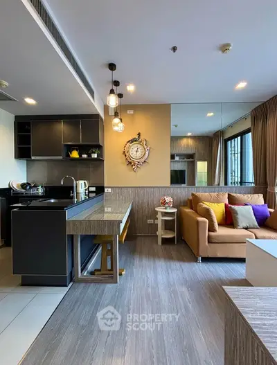 Modern open-layout living room with stylish kitchen and cozy seating area, perfect for urban living.