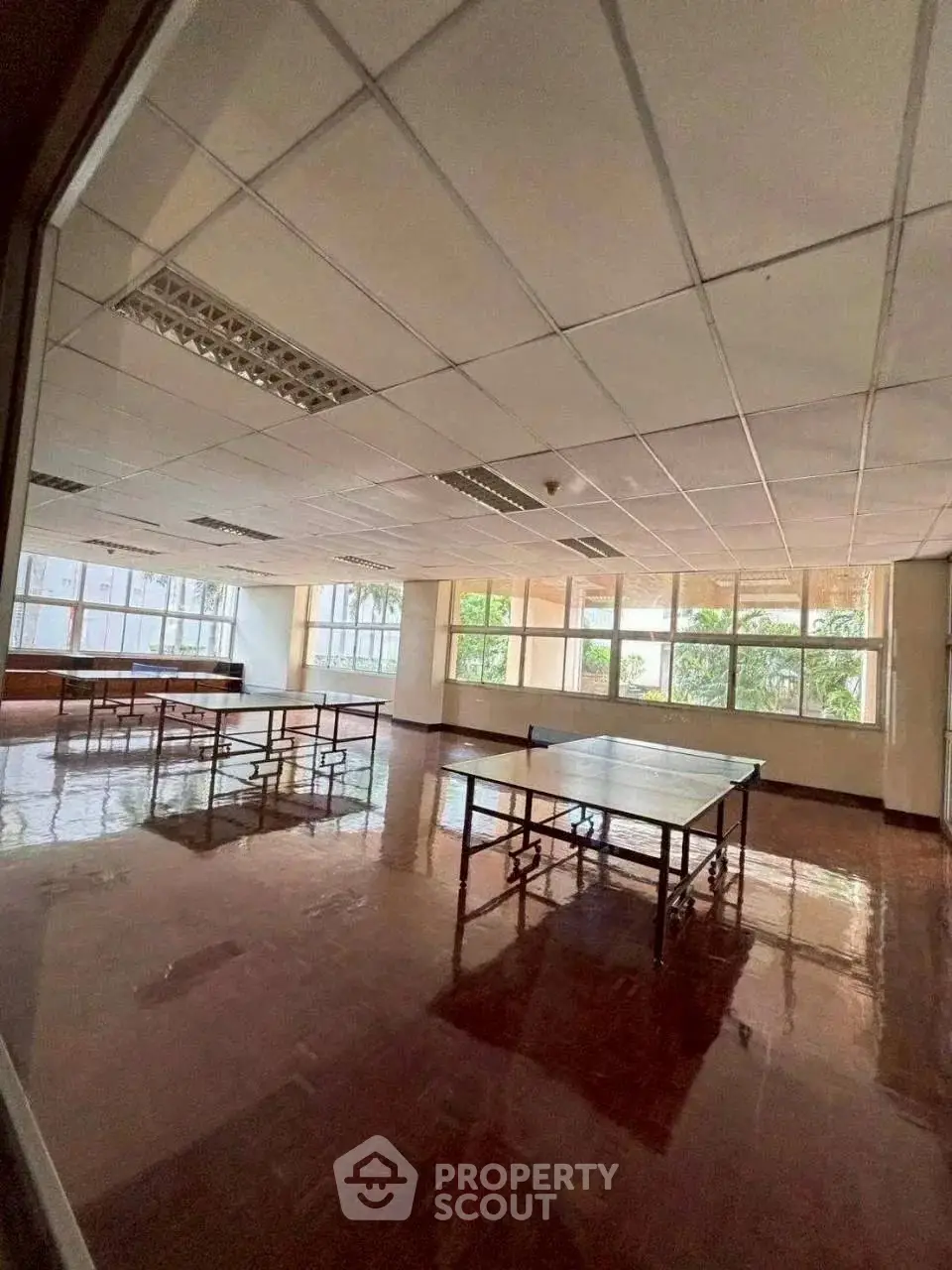 Spacious recreational room with table tennis setup and large windows offering natural light.