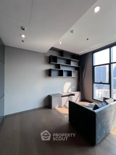 Spacious modern living room with large windows and built-in shelving, offering city views.