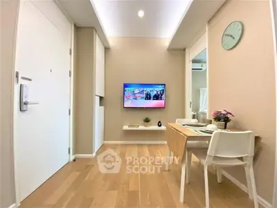 Modern living room with wall-mounted TV and dining area in stylish apartment.