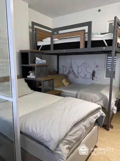 Cozy bedroom with modern bunk beds, stylish Paris-themed wall art, and ample storage, perfect for a small family or roommates.