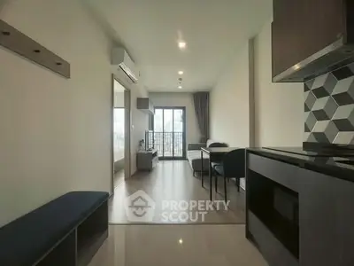 Modern open-plan living room with balcony and stylish kitchen area.