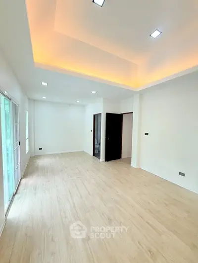 Spacious modern living room with recessed lighting and wooden flooring