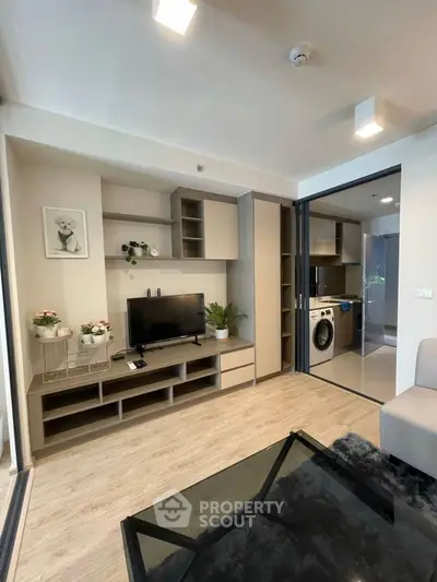 Modern living room with sleek TV unit and adjacent laundry area