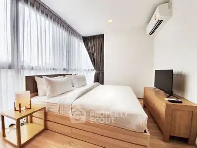 Modern bedroom with large windows, stylish furniture, and natural light.
