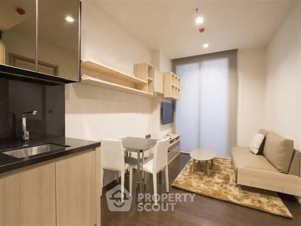 Modern open-layout living room with sleek kitchen and cozy seating area.