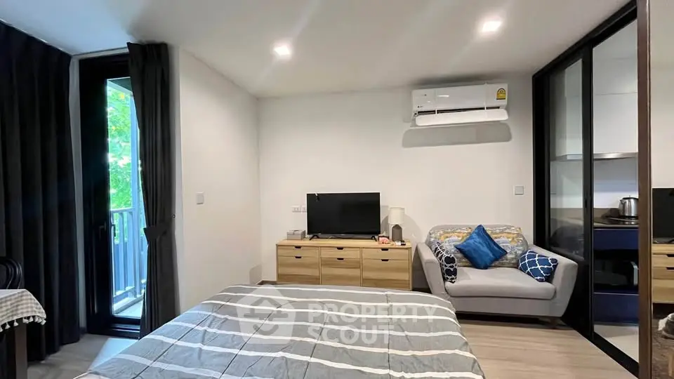 Modern studio apartment with cozy living area and balcony view