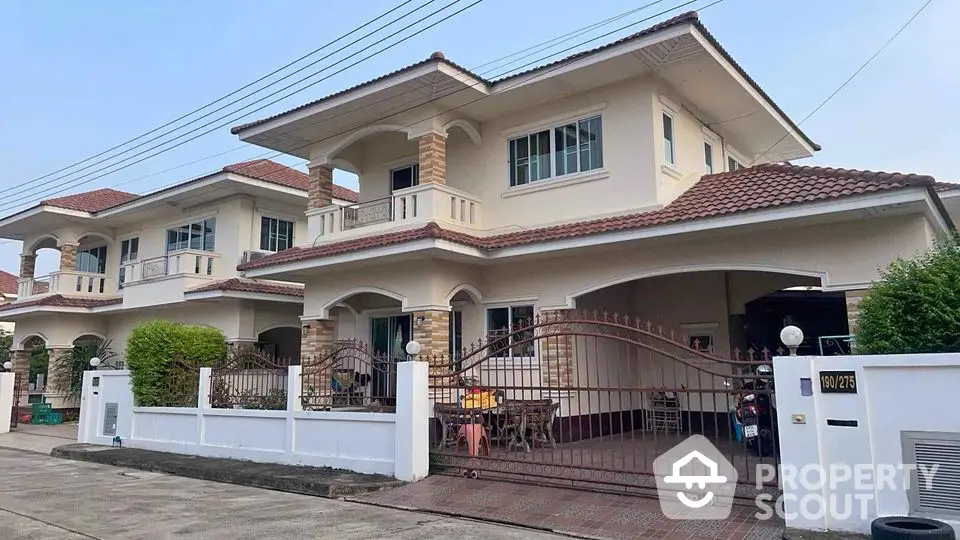 Charming two-story house with gated driveway and spacious outdoor area in a serene neighborhood.