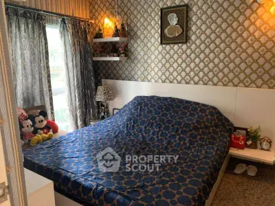 Cozy bedroom with patterned wallpaper and large window view