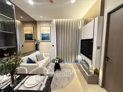 Modern living room with elegant decor and open dining area, featuring stylish furniture and ambient lighting.