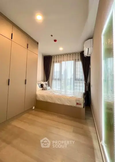 Modern bedroom with large wardrobe and natural light in stylish apartment.