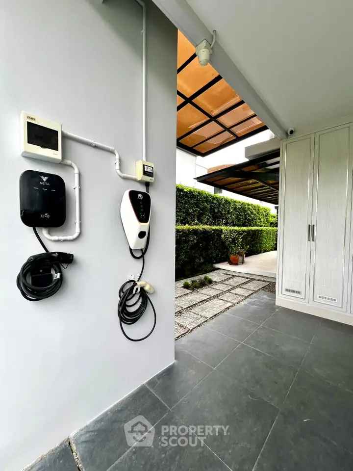 Modern home exterior with electric vehicle charging station and sleek cabinetry.