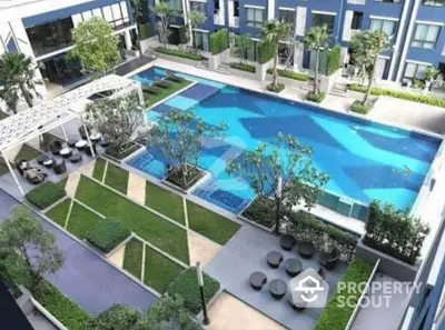 Luxurious modern apartment complex with stunning pool and landscaped garden view.