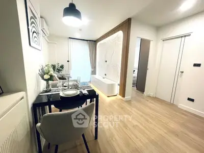 Modern living room with stylish decor and open layout, featuring elegant dining area and contemporary lighting.