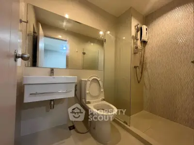 Modern bathroom with glass shower and sleek fixtures in a contemporary apartment.